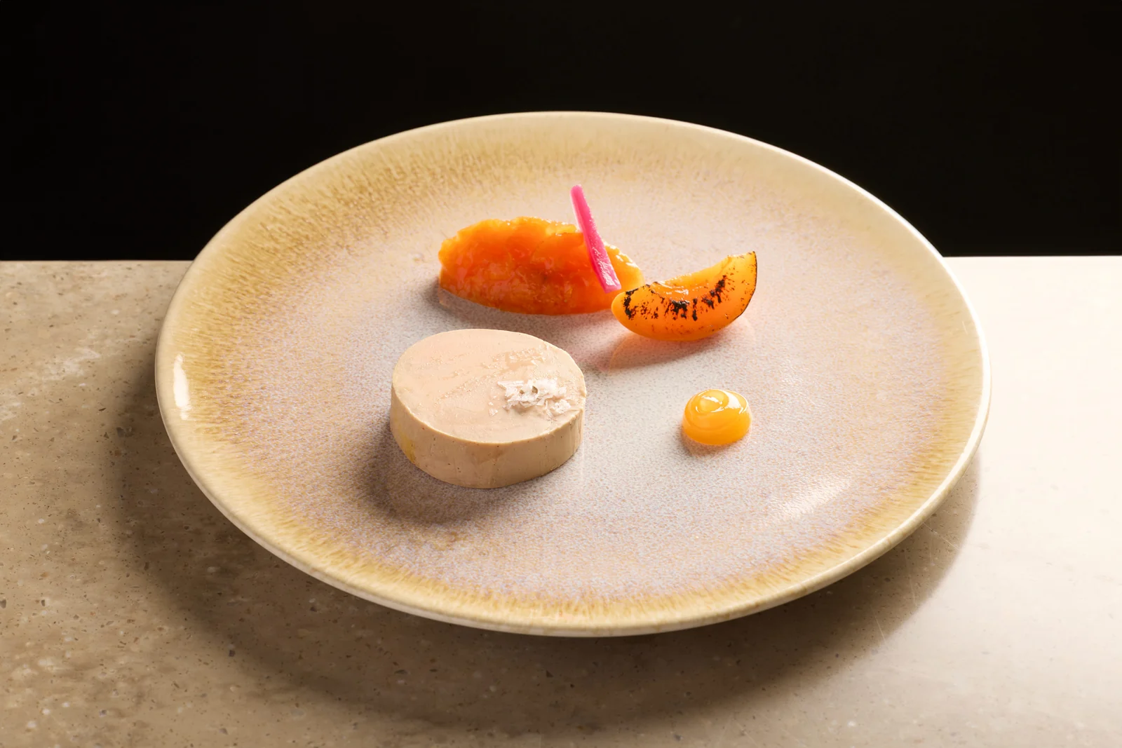 Foie gras et agrumes dans une assiette en céramique